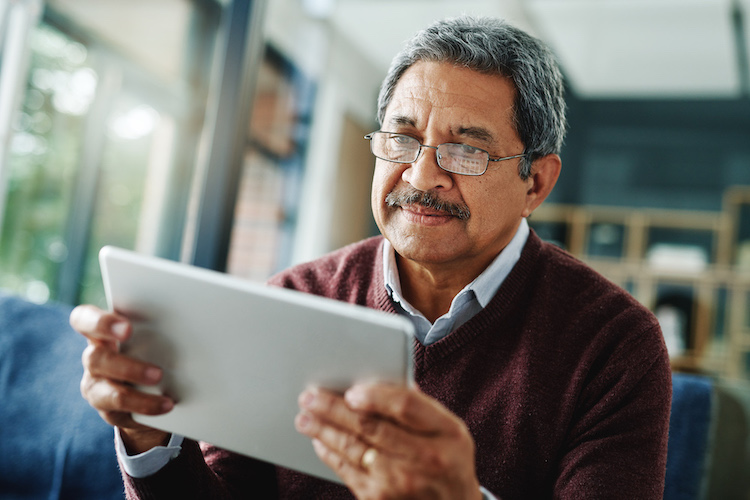 Cropped shot of a mature man using his digital tablet at home