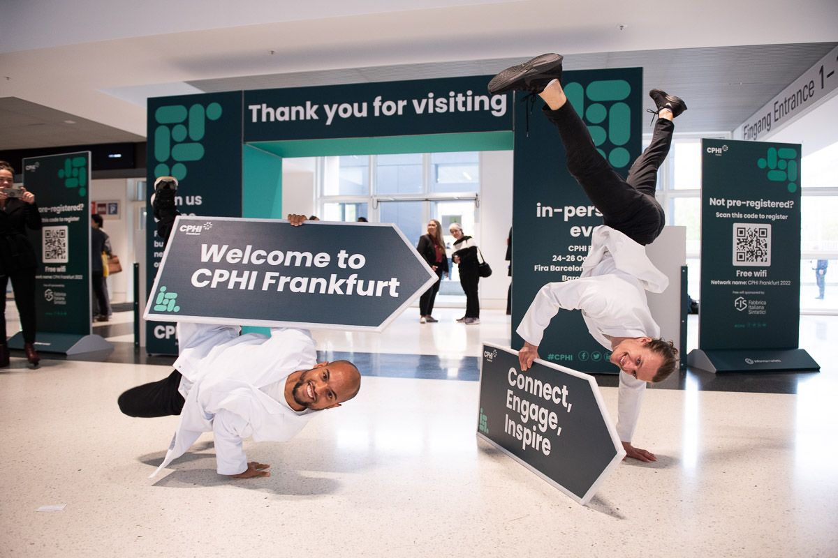 Two people juggling signs at CPHI conference