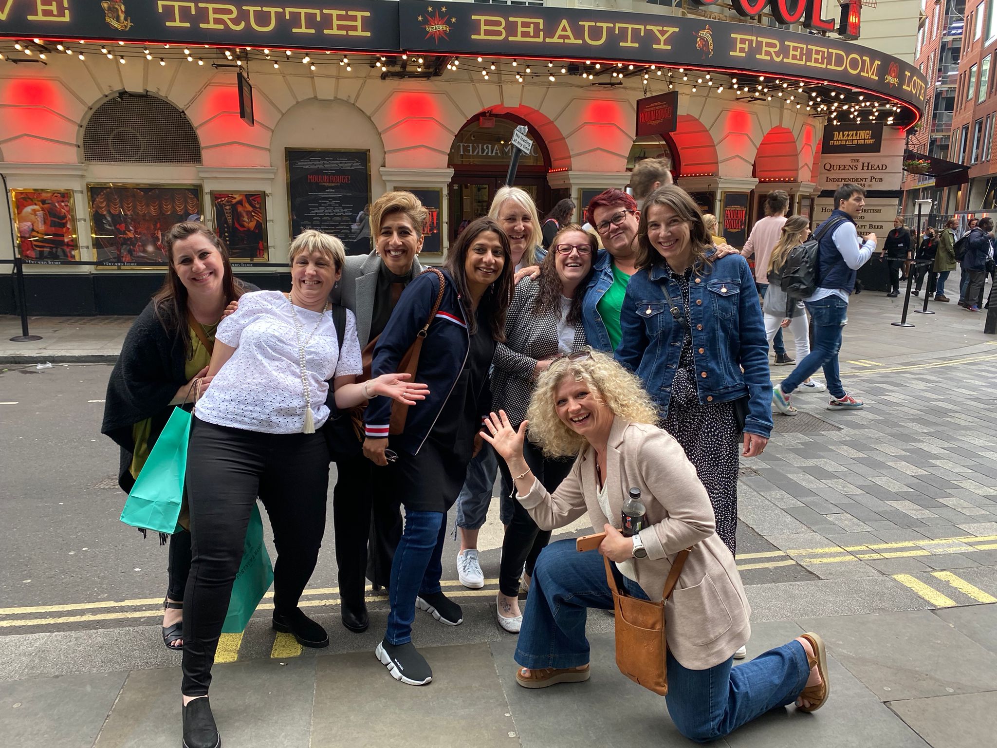 Group of people stood smiling outside a building in London