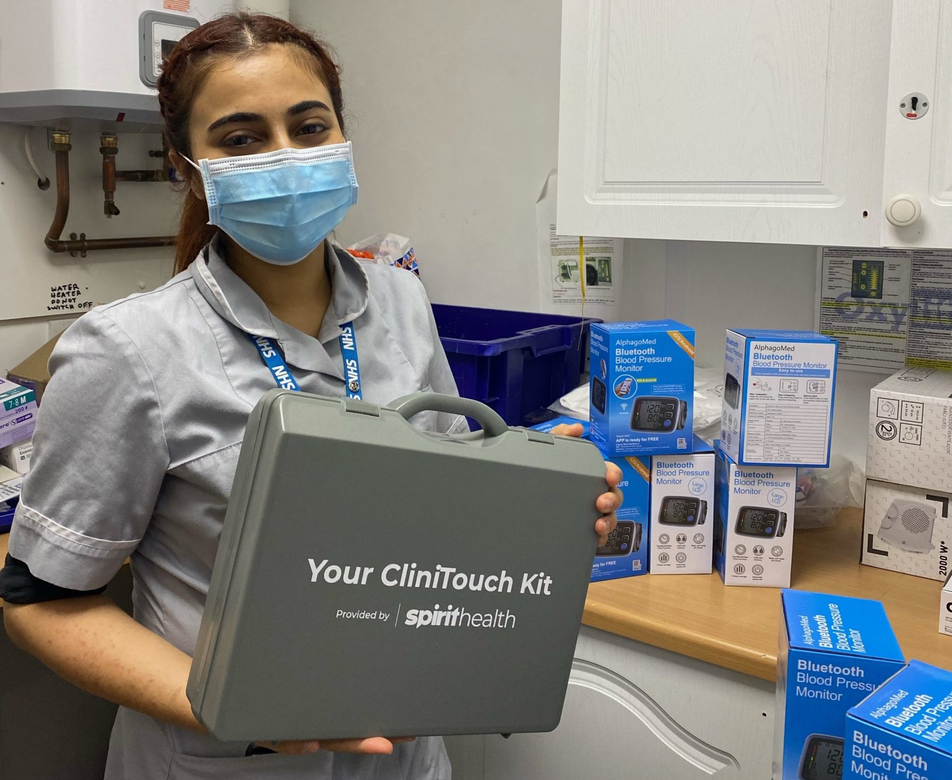 Healthcare professional holding a Clinitouch kit on the day of the asthma pathway launch. She is smiling and wearing a face mask
